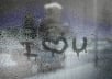write your text, message or logo on a wet window pane with raindrops